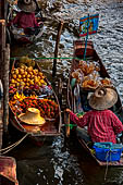Thailand, Locals sell fruits, food and products at Damnoen Saduak floating market near Bangkok